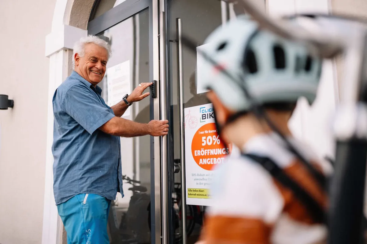 Ein Kunde öffnet die Tür des Click&Bike-Ladens in Villach per Code am Tastenfeld